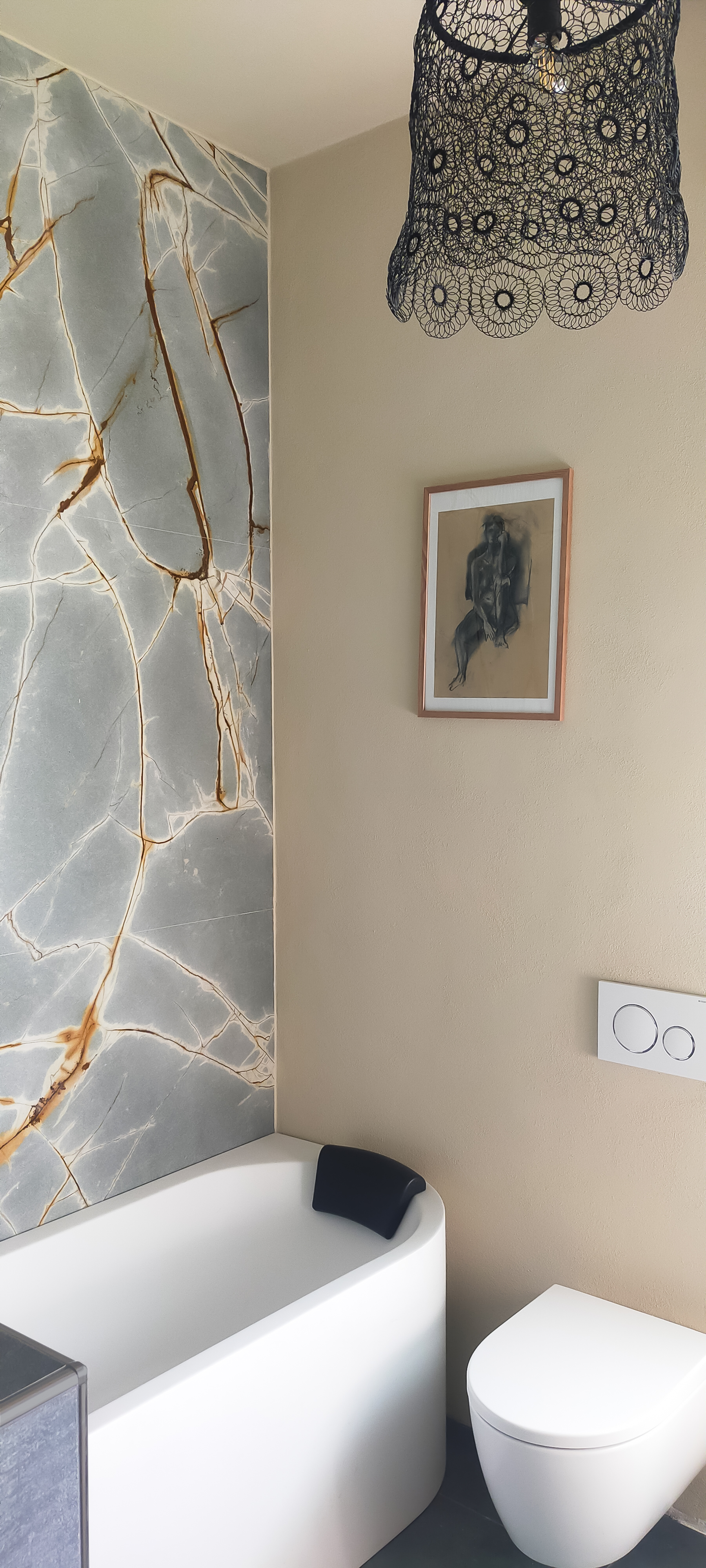 Bagno parete in marmo lampadario ferro quadro